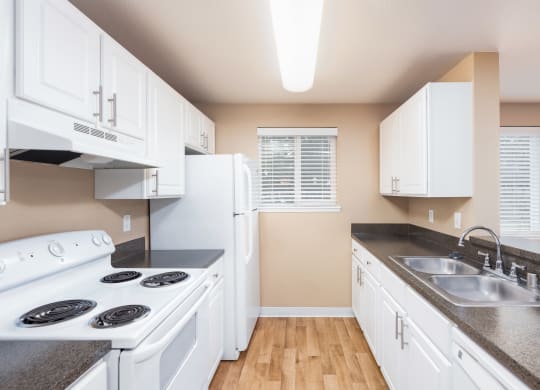 a kitchen with white appliances and counter tops and a sink