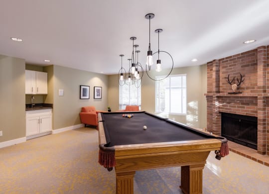 a game room with a pool table and a fireplace