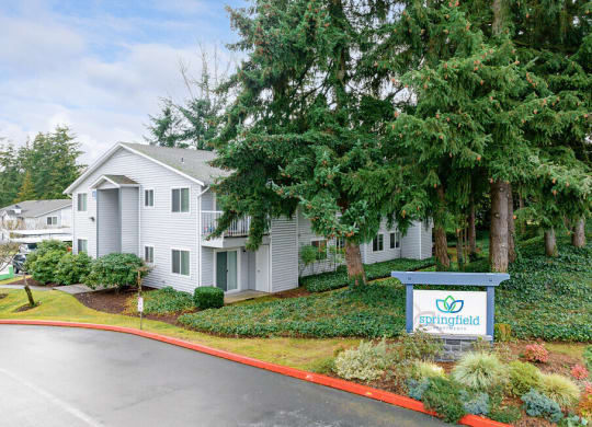 a white house with a sign and trees at Springfield, Renton, WA