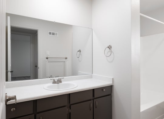 an empty bathroom with a sink and a mirror