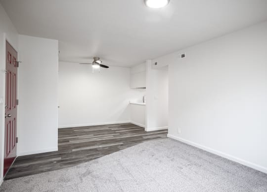 an empty living room with white walls and wood flooring