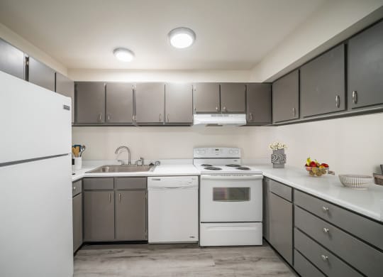 a kitchen with white appliances and gray cabinets at Summit, Pocatello Idaho