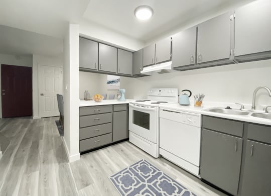 Kitchen with wood-like flooring, gray top, and bottom cabinets, looking down hallway into the dining area.at Summit, Idaho