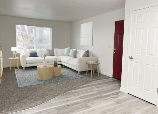 Living room with oversized window on back wall, front door, and closet on right. Staged with l-shaped couch, side tables, rug.at Summit, Pocatello, ID 83201