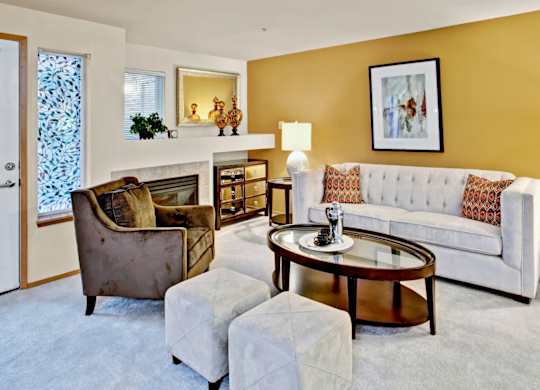 A living room with a white couch, a brown chair, and a coffee table.