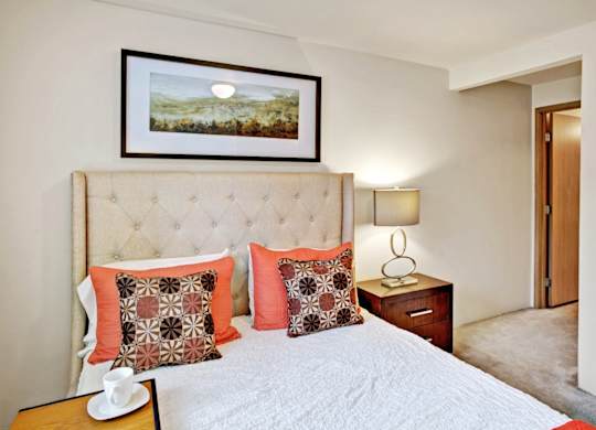 A bedroom with a large bed and a painting on the wall.