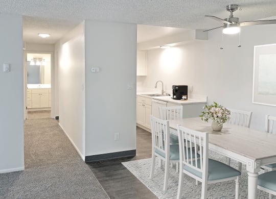 an open kitchen and dining room with a white table and chairs