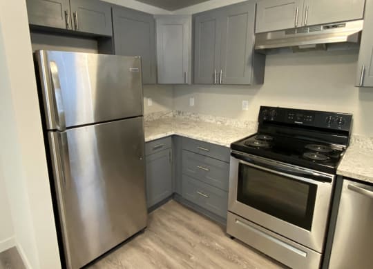 a kitchen with stainless steel appliances and marble counter tops  at The Lakes Apartments, Washington, 98837
