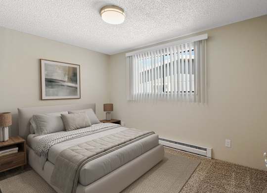 Carpeted bedroom with queen bed and large window with blinds for natural light at the Lakes Apartments in Moses Lake