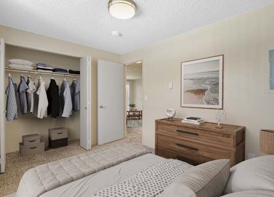 Spacious bedroom with queen bed, wood dresser, and full closet at The Lakes Apartments in Moses Lake