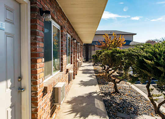 the side of a brick building with a porch and a blue door