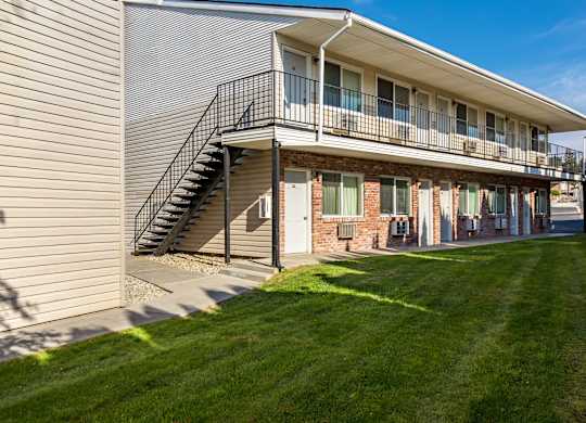the exterior of a building with a balcony and a lawn