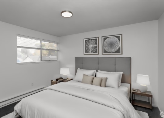 bedroom with white walls and a white bed with white sheets and pillows