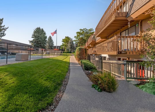 a sidewalk leading to a pool with a volleyball court in the background at Castlerock, Wenatchee, 98801
