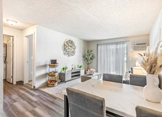 A dining room with a white table and grey chairs at Wildflower Apartments in Kennewick, WA..