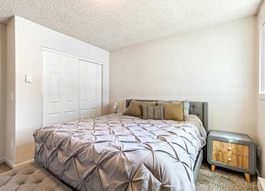 A bedroom with a bed, nightstand, and a door at Wildflower in Kennewick, WA..