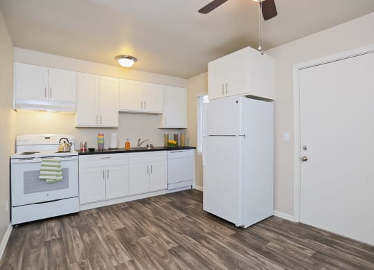 an empty kitchen with white cabinets and a white refrigerator  at Woodhaven, Everett, 98203