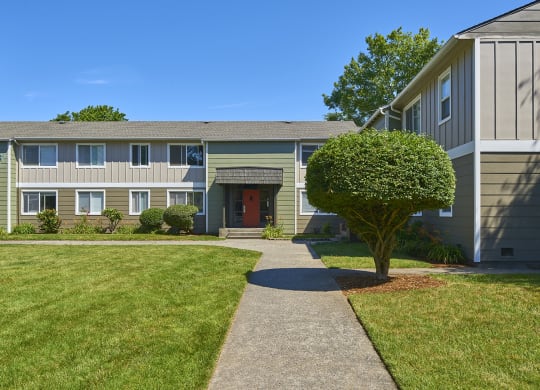 Exterior grounds with paved pathway leading through large grass area to homes.at Woodhaven, Everett, Washington