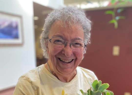 Resident enjoying gardening activity at Hilltop Commons Senior Living Apartments, California