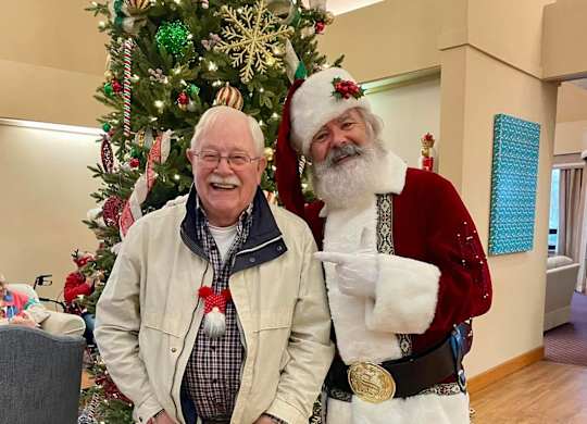 A man standing next to Santa Claus at River Commons Senior Living, Redding, CA