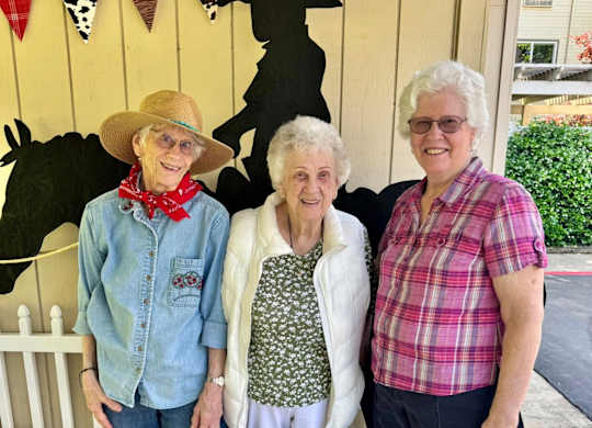 Three people smiling and posing together at River Commons Senior Living, California, 96002