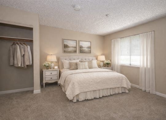 Spacious bedroom with walk-in closet and large window at Roseville Commons Senior Living Apartments, Roseville, CA