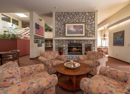 a living room with couches a table and a fireplace at Hilltop Commons Senior Living, California, 95945