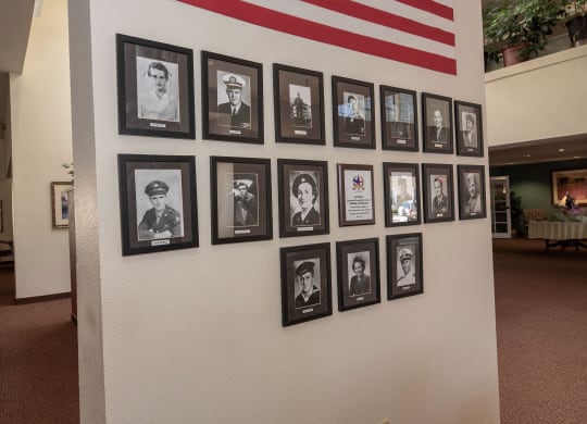 a wall of black and white photographs on a museum wall at Hilltop Commons Senior Living, Grass Valley