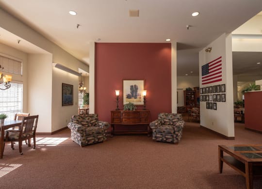 a lobby with a red wall and a table and chairs at Hilltop Commons Senior Living, California, 95945
