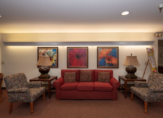 a living room with couches chairs and paintings on the wall at Hilltop Commons Senior Living, Grass Valley, CA 95945