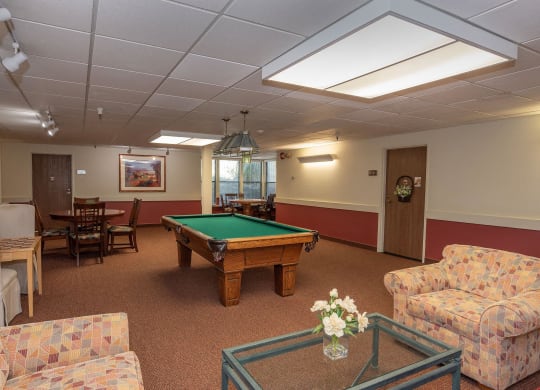 a game room with a pool table and couches at Hilltop Commons Senior Living, Grass Valley, 95945
