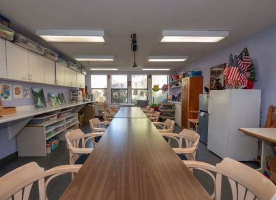 a classroom with a long table and chairs and a window at Hilltop Commons Senior Living, California, 95945