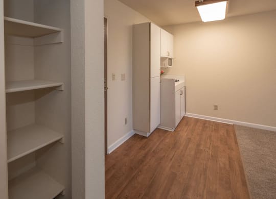a renovated living room and kitchen with a wood floor and white appliancesat Hilltop Commons Senior Living, Grass Valley, CA 95945