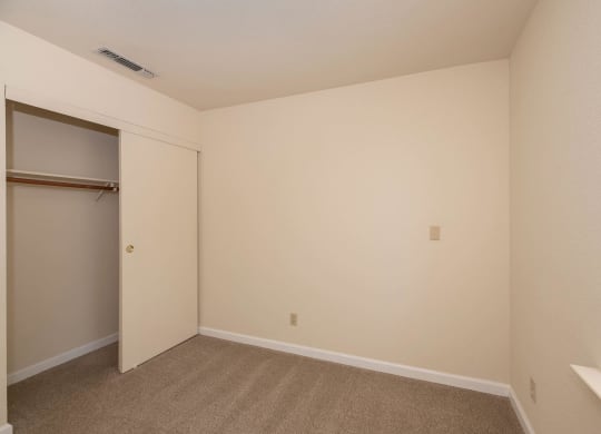 an empty bedroom with a closet and a window at Hilltop Commons Senior Living, California, 95945