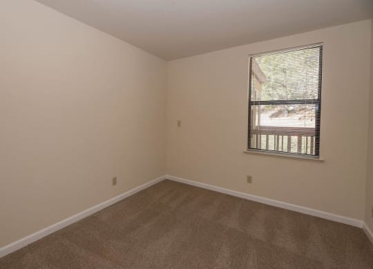 an empty room with carpet and a window at Hilltop Commons Senior Living, California