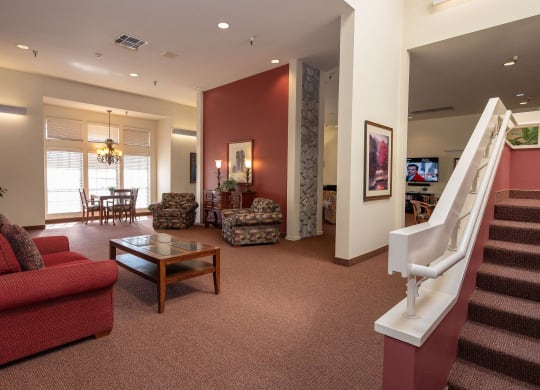 a living room with a staircase and a couch and a table at Hilltop Commons Senior Living, California, 95945