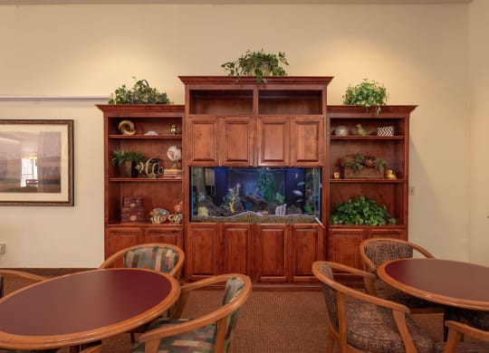 a dining room with tables and a fish tank at Hilltop Commons Senior Living, Grass Valley