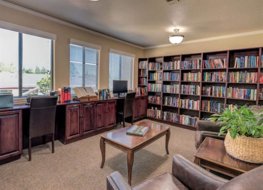 a library with a desk and shelves of books at Lodi Commons Senior Living, California, 95240