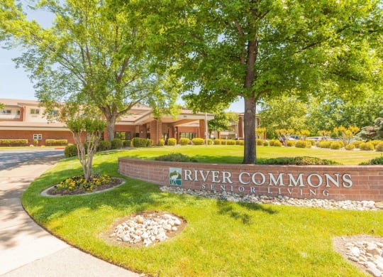 a sign for river commons in front of a building at River Commons Senior Living, California