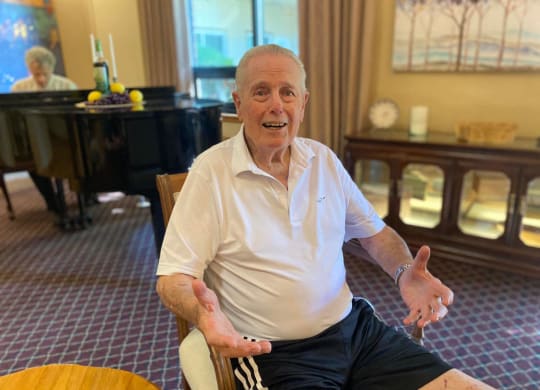 an older man sitting in a chair in a hotel room at River Commons Senior Living, California, 96002