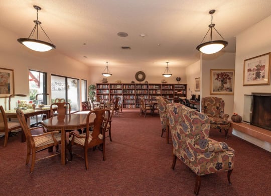 a living room with a table and chairs and a fireplace at Roseville Commons Senior Living, Roseville