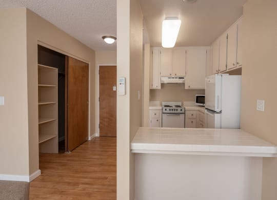 an empty kitchen with white cabinets and a white counter top at Roseville Commons Senior Living, Roseville, CA