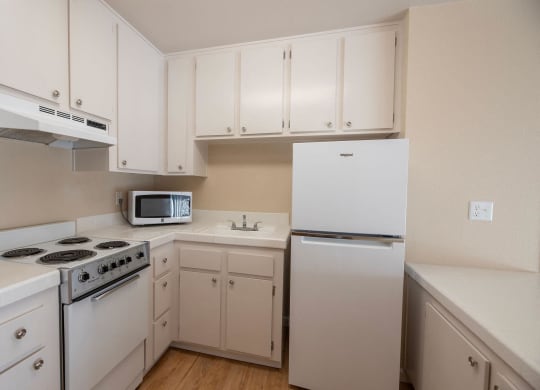 the preserve at ballantyne commons apartment kitchen with white cabinets and appliances at Roseville Commons Senior Living, Roseville California