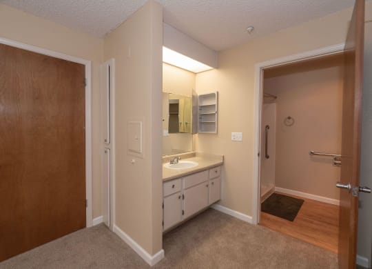the interior of a bathroom with a sink and mirror at Roseville Commons Senior Living, Roseville California