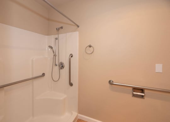 a bathroom with a shower and grab bars at Roseville Commons Senior Living, Roseville, 95678