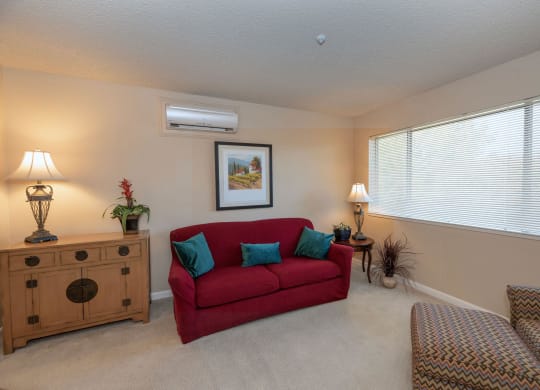 a living room with a red couch at Roseville Commons Senior Living, California, 95678