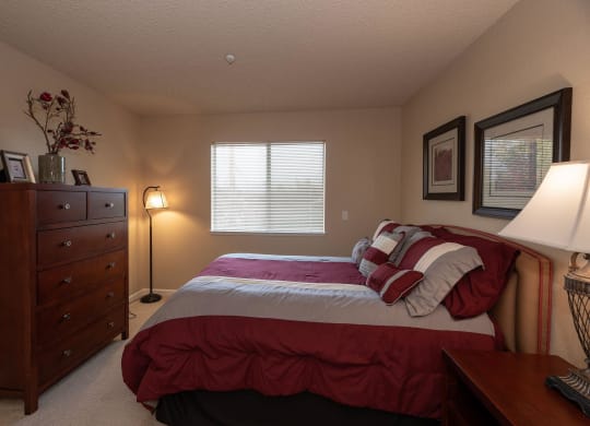 a bedroom with a bed and a dresser at Roseville Commons Senior Living, Roseville, CA