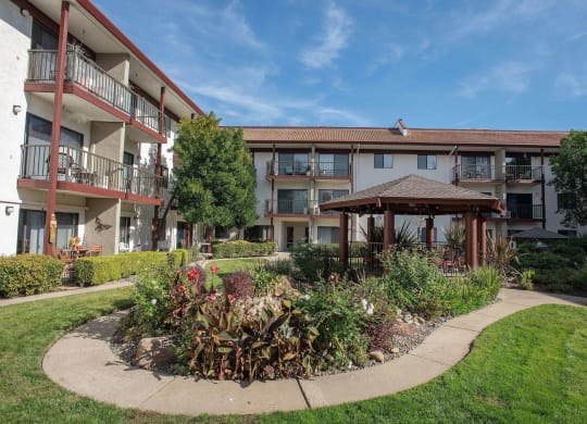 a courtyard with a gazebo in front of an apartment building at Roseville Commons Senior Living, Roseville, CA 95678