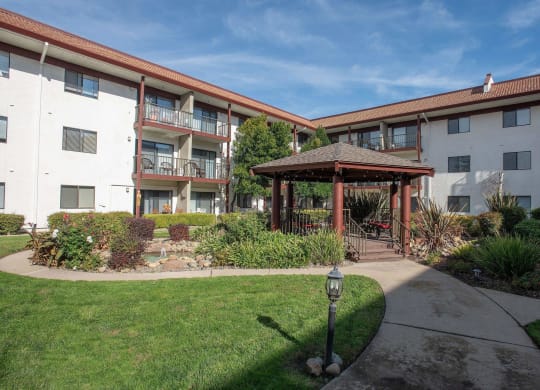 a courtyard with a gazebo in the middle of an apartment building at Roseville Commons Senior Living, California, 95678