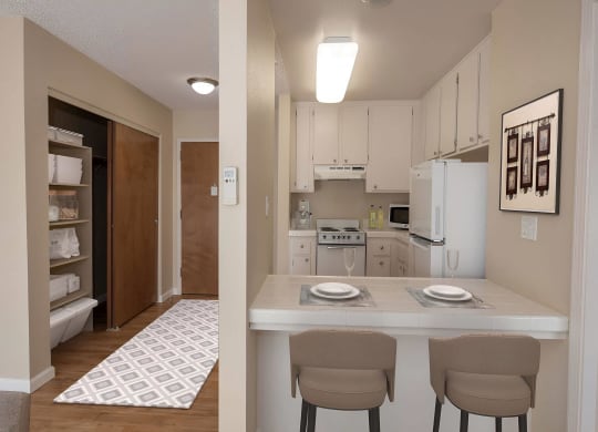 a view of a kitchen and a living room with a table and chairs at Roseville Commons Senior Living, California
